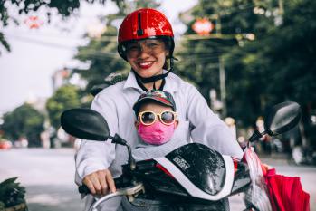 baby wearing pollution mask on scooter